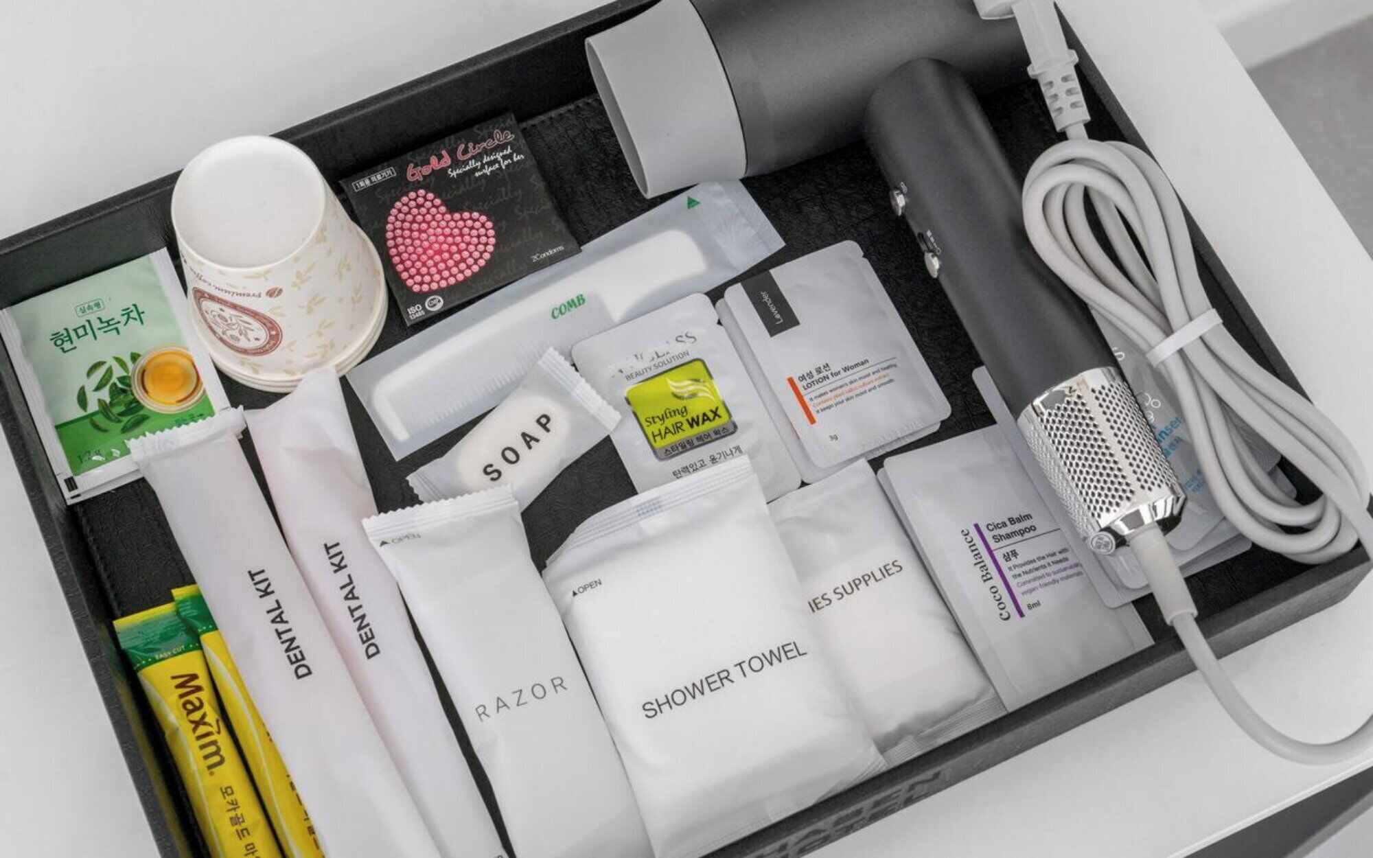 Une trousse de toilette de voyage contenant des articles de toilette, notamment un rasoir, du savon, du shampoing et une serviette de bain.