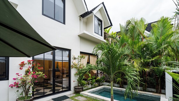 A modern house with a swimming pool, potted plants, and a covered patio. - Orfeas Villas 2 Canggu Villa 2BR Pool (Canggu)