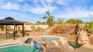 A swimming pool with a hot tub, a gazebo, and a rock waterfall feature. - Resort-Style Home with Backyard & Heated Pool : A Luxe Tucson Home (Tucson)