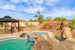 Ein Pool mit Whirlpool, einem Pavillon und einem Wasserfallgestein.
