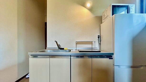 A compact kitchen with a sink, a microwave, and a refrigerator.