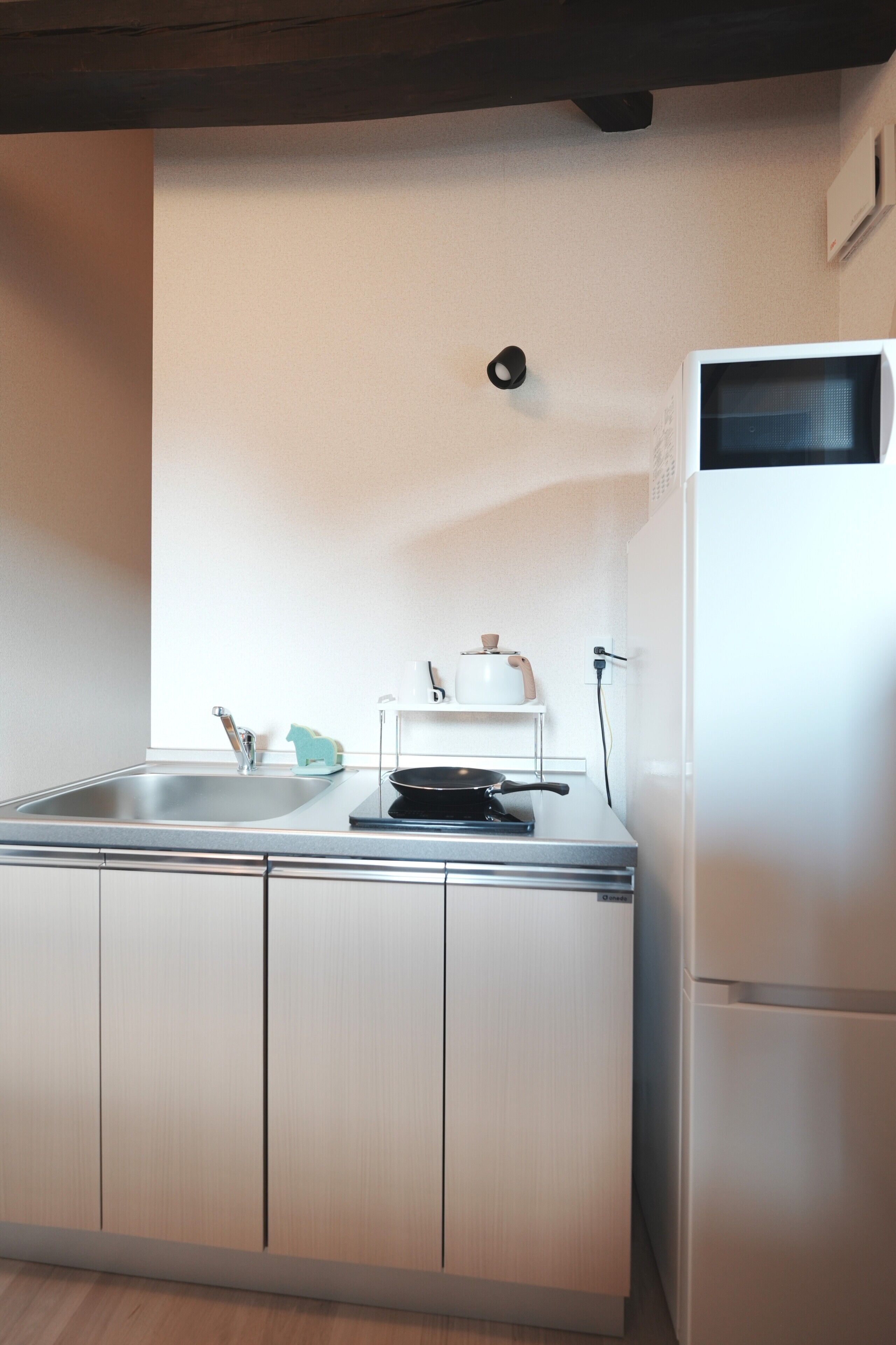 A compact kitchen with a sink, a stove, and a white refrigerator.