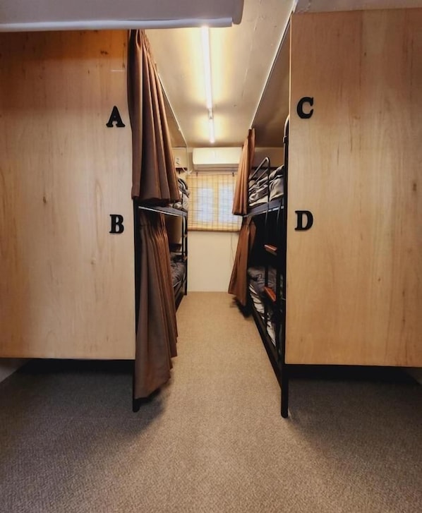 A corridor with wooden walls, labeled sections A, B, C, and D, leading to a room with a window and a door. - Zen Seoul Stay (Seoul)
