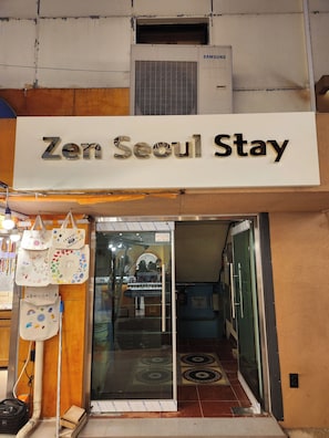 A hotel entrance with a sign reading 'Zen Seoul Stay,' a glass door, and a view into the interior. - Zen Seoul Stay (Seoul)