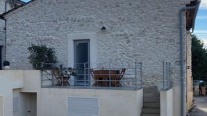 Un bâtiment en pierre doté d’un balcon, d’une porte et d’une petite fenêtre.