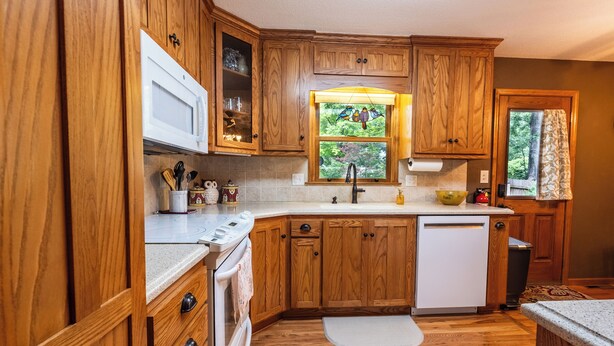 Une cuisine avec des meubles en bois, un four à micro-ondes, un évier et une fenêtre donnant sur un beau paysage.