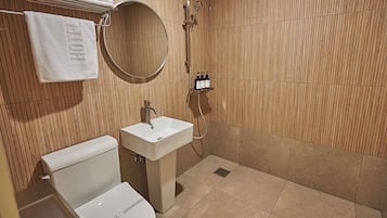 A hotel bathroom with a toilet, sink, shower, and a towel rack with a towel labeled 'HOTEL'.