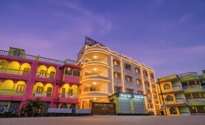 A hotel with a prominent curved facade, multiple balconies, and a sign indicating it is 'The Golden Plaza Hotel.'