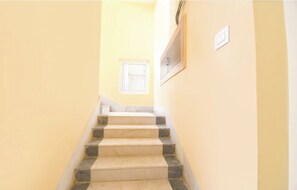 A staircase with alternating beige and gray steps leading to a landing.