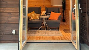 An open sliding door leading to a room with two sofas, a small table, and a window with a view.