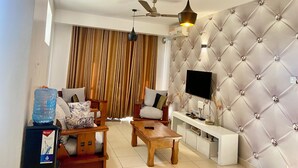 Sala de estar con sofá, mesa de centro, televisor y dispensador de agua.
