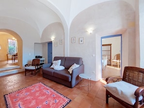 A living room with a sofa, chairs, a small table, a rug, and a door leading to another room. - Casa Memmi Mouriès by Interhome (Palasca)