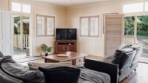 A living room with a TV, wooden cabinet, and two sofas.