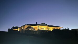 Una casa con tetto spiovente, ampie finestre e un portico luminoso.