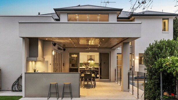 A modern two-story house with an open-plan kitchen and dining area, a covered patio, and a well-maintained lawn. - The Anchorage on Henley (Charles Sturt)