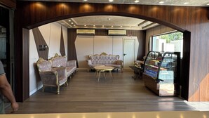A lobby with a seating area, a vending machine, and a ceiling with recessed lighting.