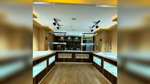 Una cocina moderna con armarios de madera, electrodomésticos integrados y vitrinas de vidrio.