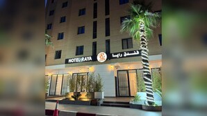 Un edificio de hotel de varios pisos con un letrero que dice 'HOTEL RAYA' y texto en árabe.