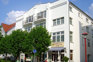 Ein weißes Gebäude mit einer Bar namens 'Espresso Bar' im Erdgeschoss.