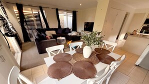 A dining area with a white table and chairs, surrounded by woven placemats.