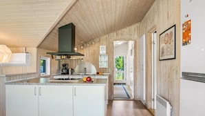 Una cocina moderna con paneles de madera, una isla central y vistas al exterior.