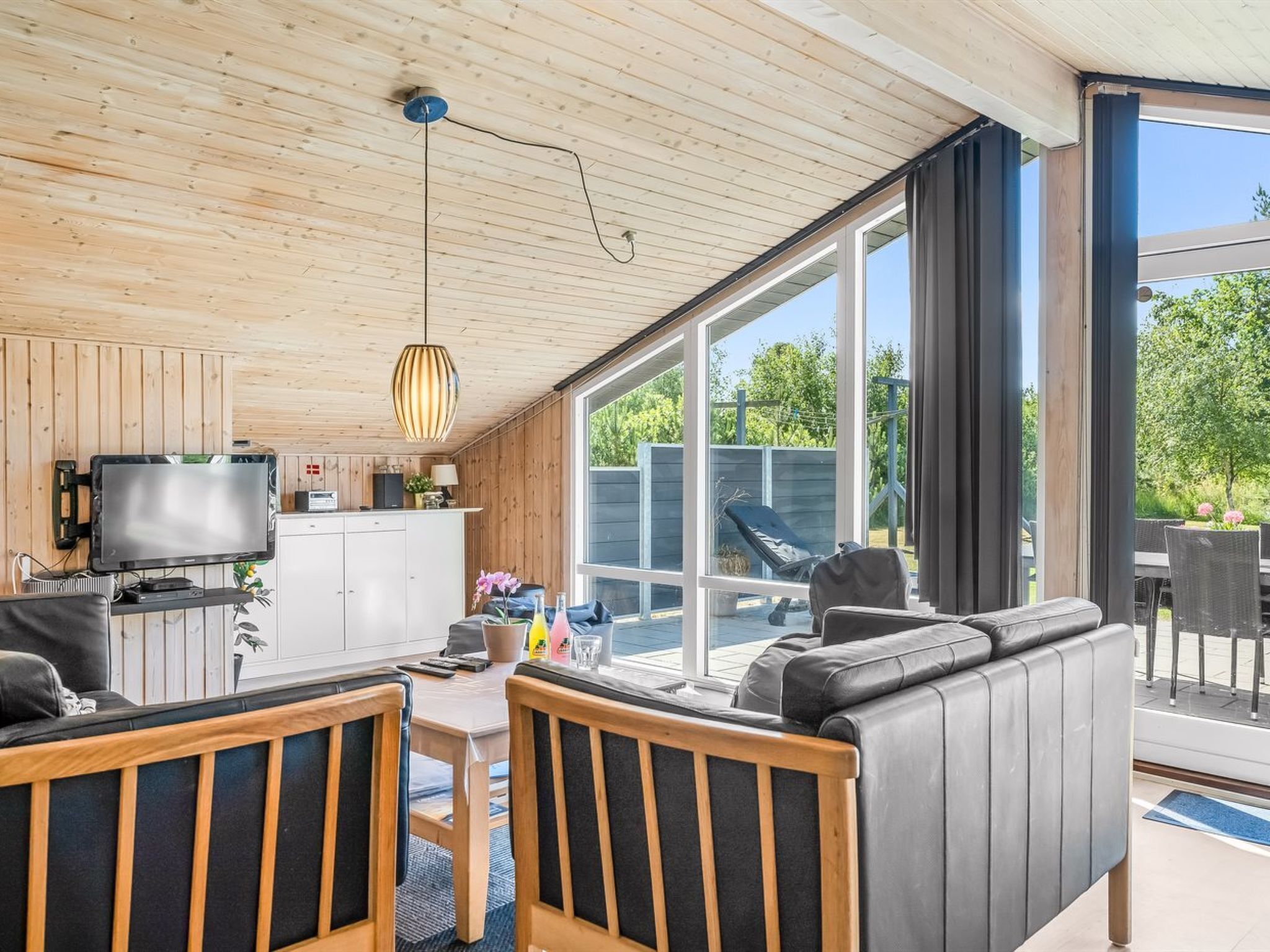 En moderne stue med fjernsyn, sofa og spiseområde.