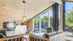 Una sala de estar moderna con televisión, sofá y comedor.