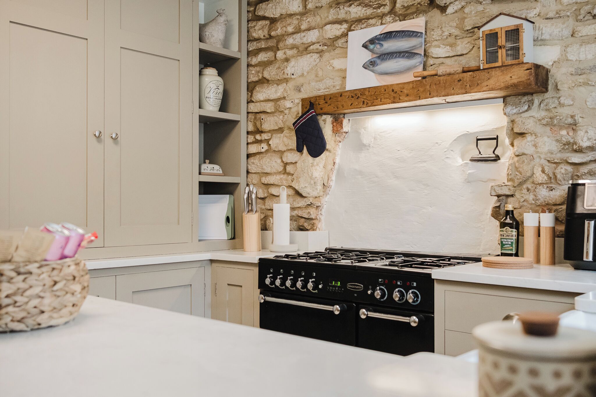A kitchen with a stone wall, wooden shelf, and a stove.