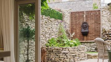 A modern interior with a glass door leading to a stone wall garden.