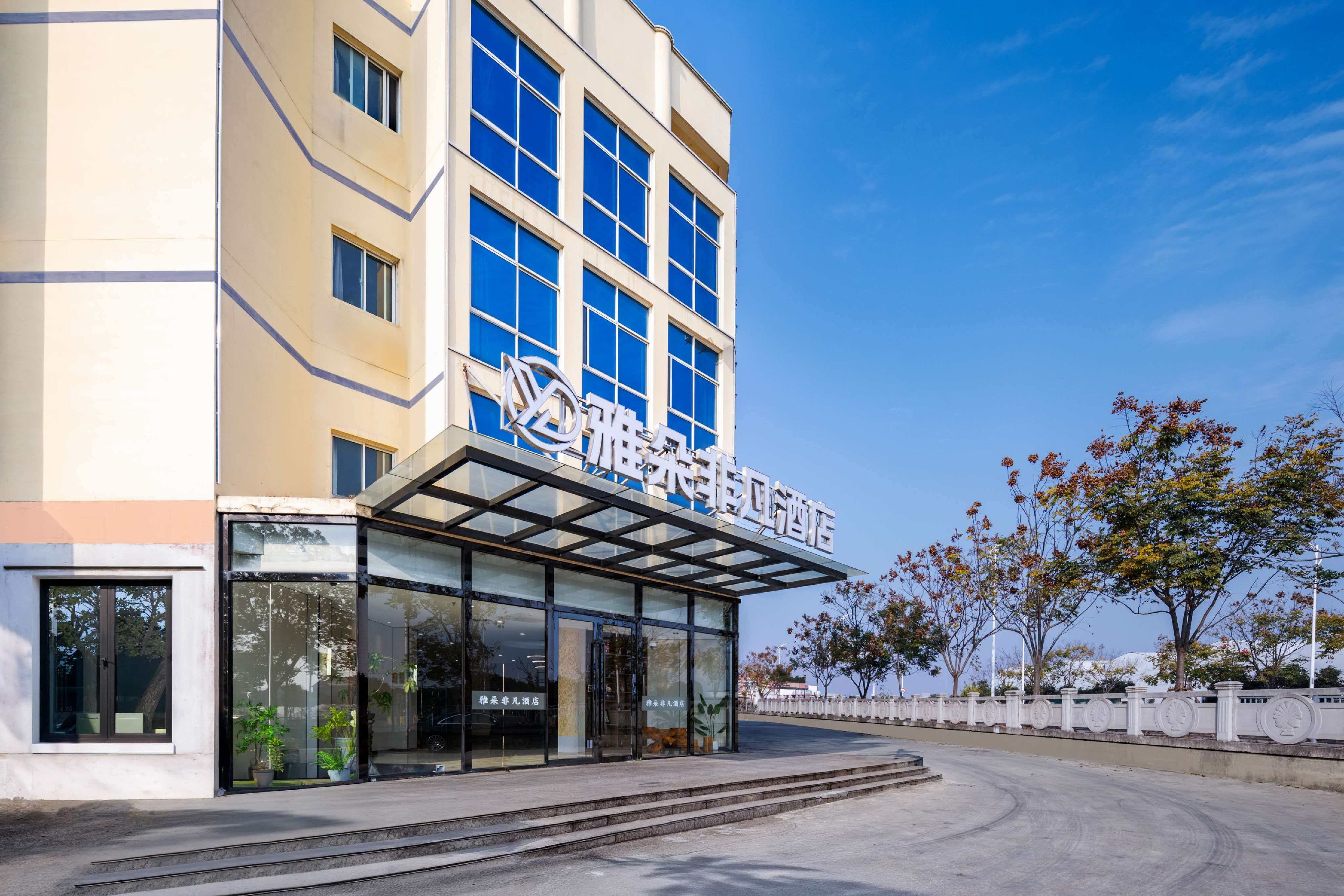 Un hotel con fachada moderna, amplias ventanas y cielo despejado.