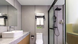 A modern bathroom with a white sink, toilet, and shower.