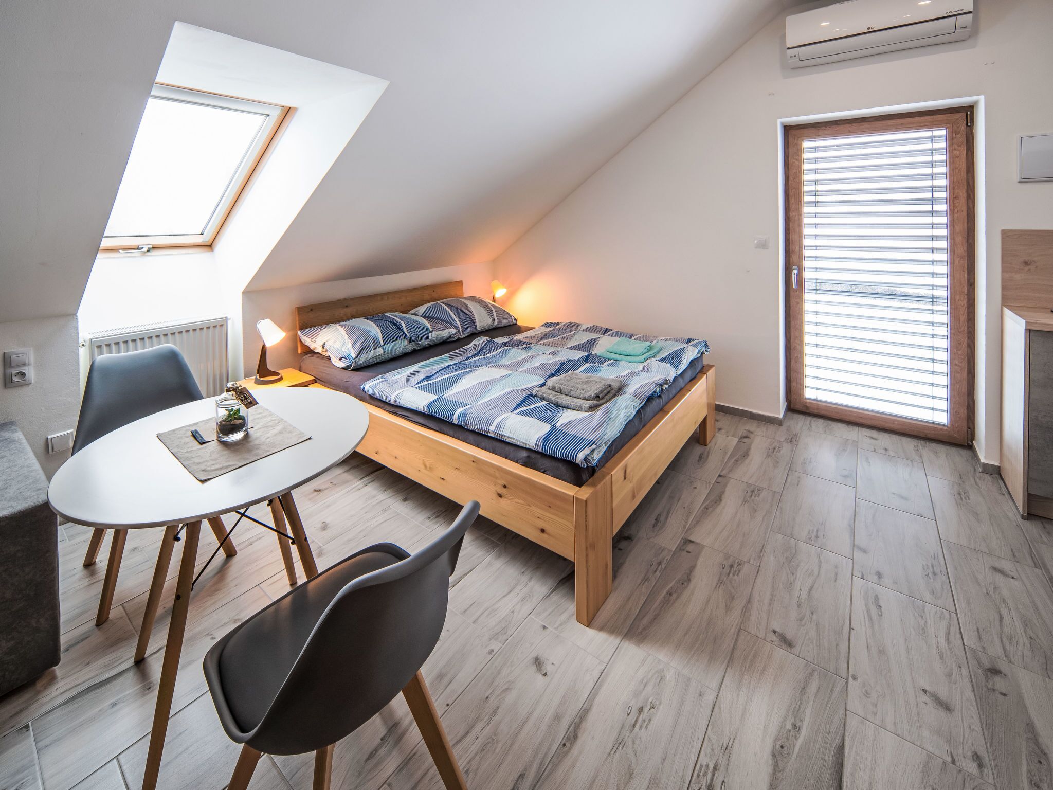 Un dormitorio pequeño y moderno con cama estilo loft, una mesa de comedor y una silla.