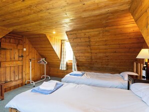 A wooden cabin with two beds, a coat rack, and a lamp. - Strathnoon by Interhome (Tomatin)
