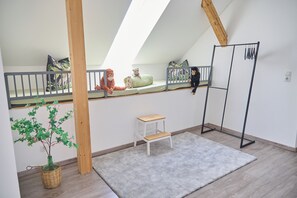 A child's room with a bunk bed, a small table, a plant, and a radiator. - Villa Rebgarten (Höchst)