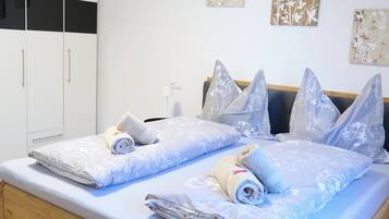 A double bed with a wooden frame, two bedside tables, and a nightstand.