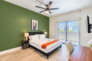 A hotel room with a bed, bedside tables, a ceiling fan, a window with a view, and a TV mounted on the wall. - Westgate Escape  Pool, Gym & Walk to Stadium (Glendale)