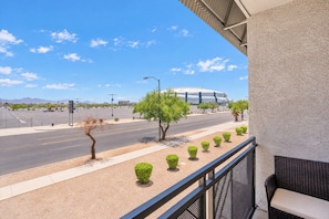 A balcony with a view of a road, a modern building, and a clear sky. - Modern Westgate Condo  Pool Gym Parking WD (Glendale)