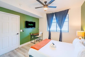 A hotel room with a bed, a desk, a television, and a ceiling fan. - Westgate Stadium Stay  Pool Gym WD Parking (Glendale)