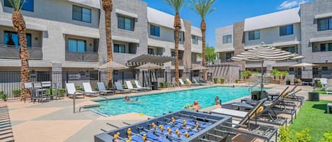 A pool area with lounge chairs, a foosball table, and a sign indicating a splash zone.
