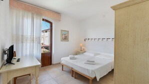 Une chambre à coucher avec un lit, une table de chevet, une lampe et une vue sur l’extérieur.