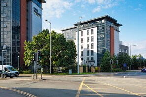 A multi-story building with a modern architectural style, featuring large windows and a mix of glass and brick facades. - Student Only Adam Street Gardens (Cardiff)
