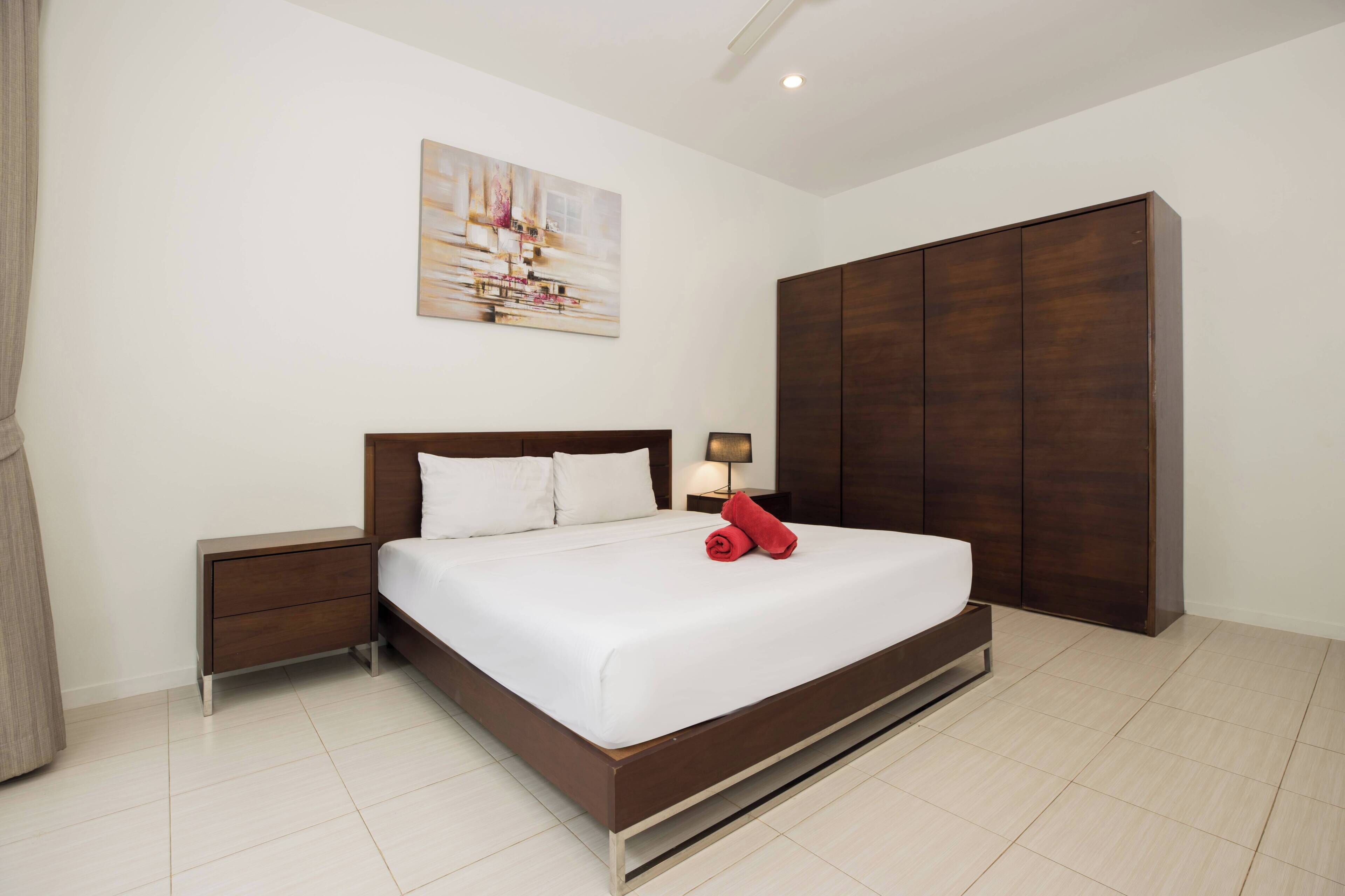 Un dormitorio con cama, mesita de noche, armario y un cuadro en la pared.