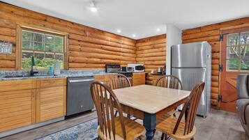 A modern kitchen with wooden walls, granite countertops, and stainless steel appliances.