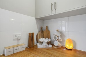 Eine Küche mit weißen Schränken, einem Holztisch zum Schneiden und einer Teekanne, sowie einem Buch mit dem Titel 'Simple Dinners'.