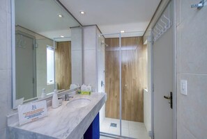 A modern bathroom with a glass shower enclosure, a marble sink, and a large mirror. - Corporate Stays Edificio Pilar - N3B (Asunción)