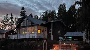 Une propriété située au bord de l’eau, dotée d’un quai, d’une maison avec balcon et d’un bateau.
