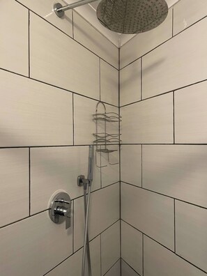 Eine Dusche mit Handbrause und einer fest installierten Armatur.