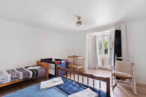 Une pièce comprenant un lit, une petite table, une chaise et une fenêtre avec des rideaux.