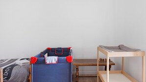 Een slaapkamer met een stapelbed, een houten tafel en een schaakbord.