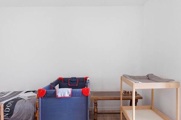 Un dormitorio con una litera, una mesa de madera y un tablero de ajedrez.